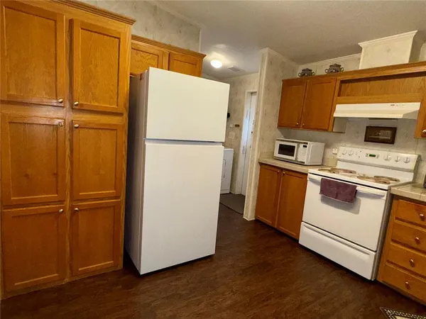 a white refrigerator freezer and a stove sitting inside of a kitchen