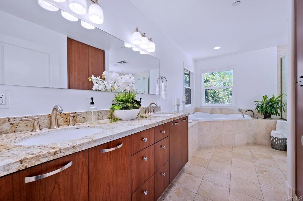 647 Arden Drive Encinitas, CA 92024 - Photo 20 of 36 a bathroom with a granite countertop sink a large mirror and a bathtub