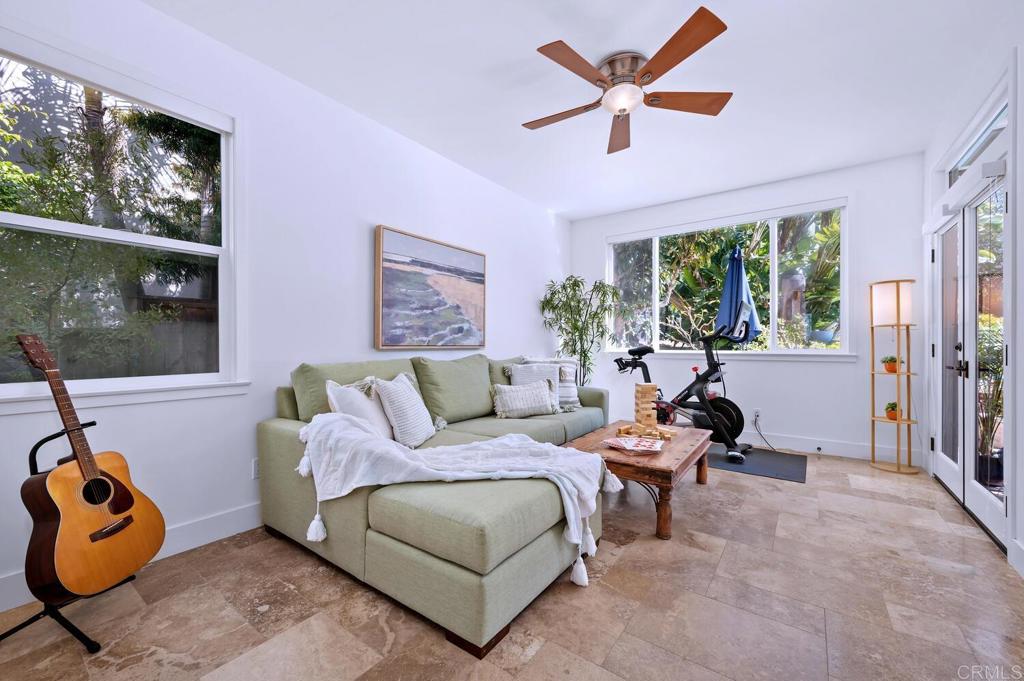 647 Arden Drive Encinitas, CA 92024 - Photo 23 of 36 a living room with furniture a flat screen tv and a floor to ceiling window