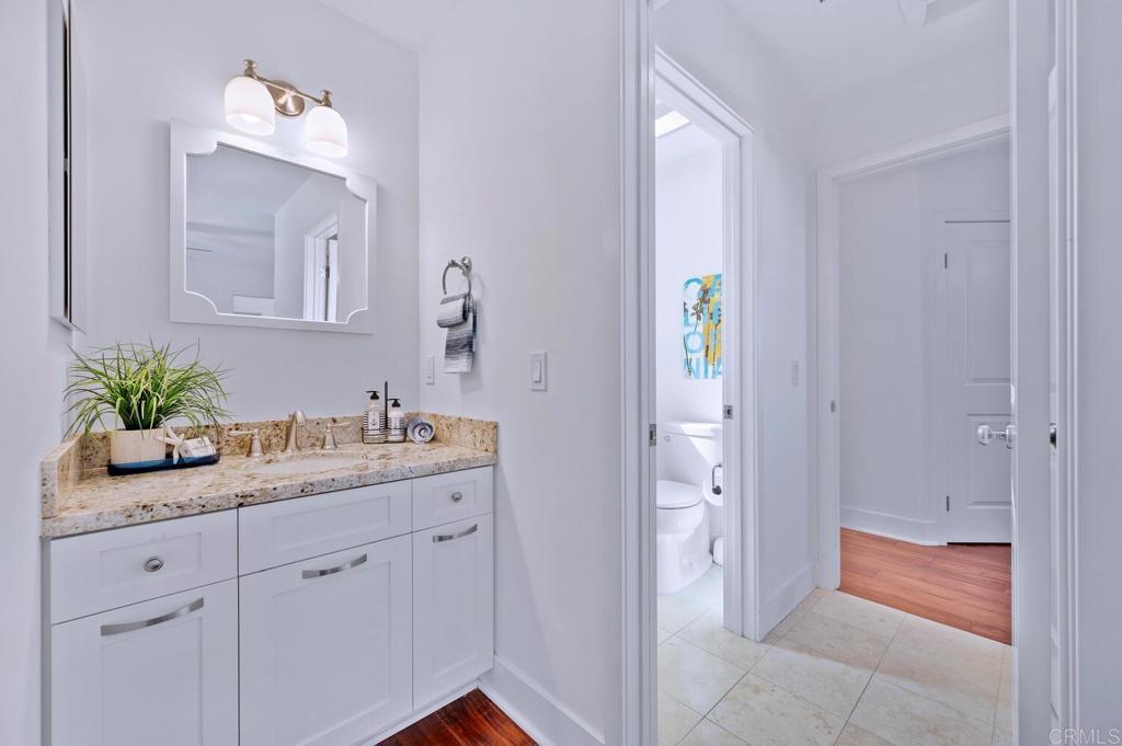 647 Arden Drive Encinitas, CA 92024 - Photo 26 of 36 a bathroom with a granite countertop sink a toilet and mirror