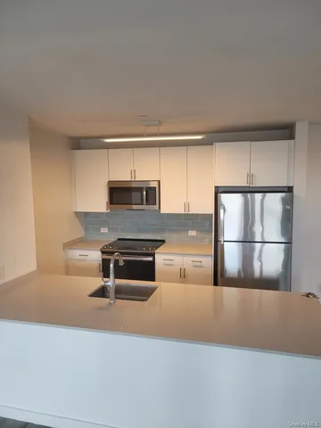 a kitchen with kitchen island a stove a sink and a refrigerator