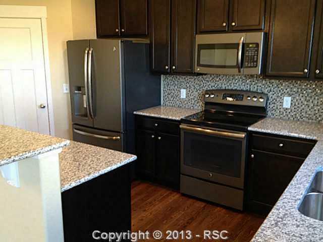 2464 Reed Grass Way Colorado Springs, CO 80915 - Photo 3 of 11 Slate appliances and glass tile backsplash