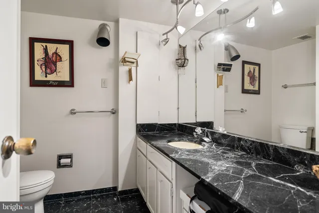 a bathroom with a granite countertop sink and a mirror