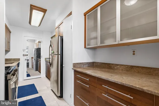 a kitchen with stainless steel appliances granite countertop a refrigerator and a stove
