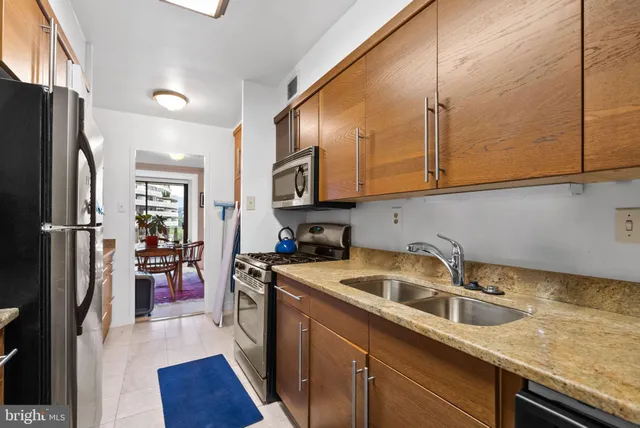 a kitchen that has a sink a refrigerator and cabinets