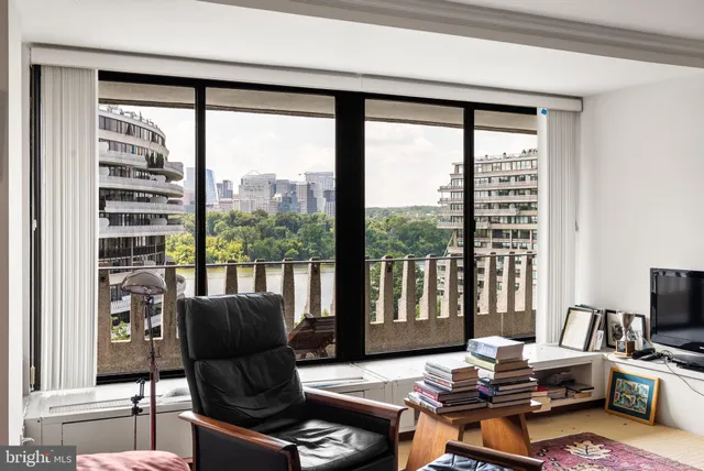 a living room with furniture and a floor to ceiling window