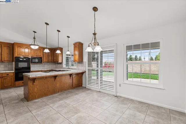 a kitchen with stainless steel appliances granite countertop a sink a stove and a refrigerator