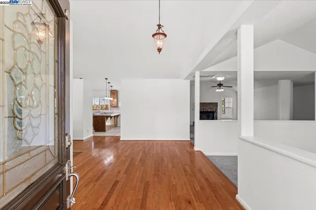 a view of empty room with wooden floor and window