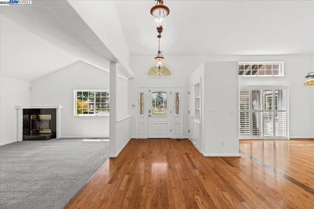 a view of an empty room with a fireplace and a window