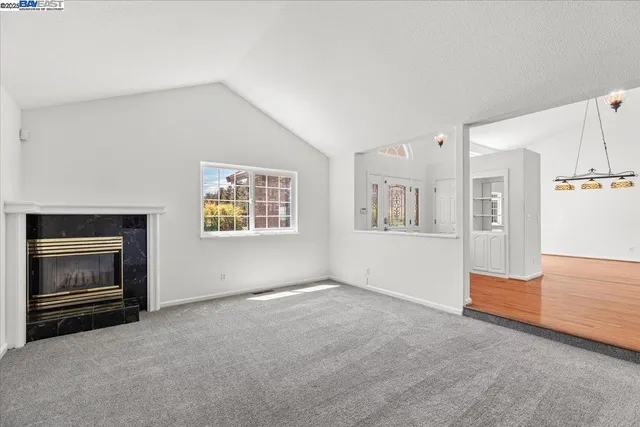 a view of empty room with wooden floor and ceiling fan
