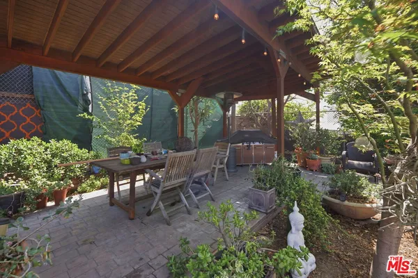 a view of a patio with table and chairs and potted plants