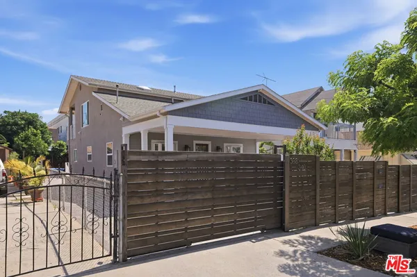 a front view of white house with a fence
