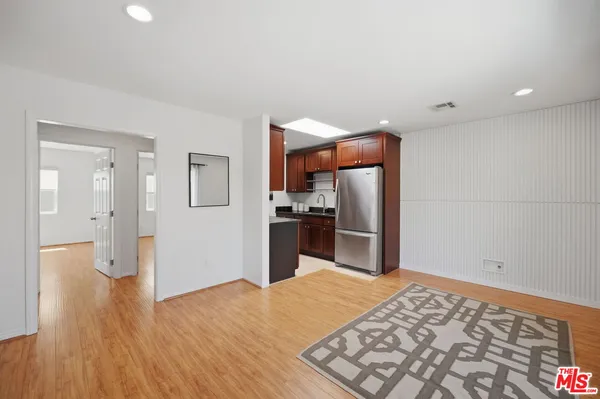 a kitchen with stainless steel appliances kitchen island granite countertop a refrigerator and a sink