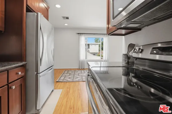 a kitchen with kitchen island a counter space a sink and stainless steel appliances