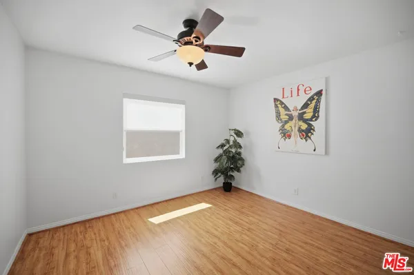 a view of empty room with a window and wooden floor