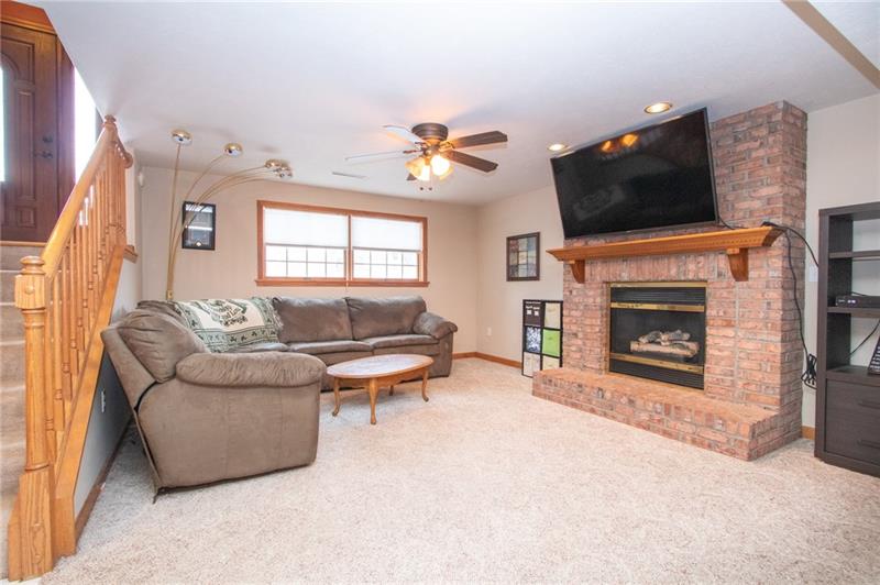 5550 Dutch Ridge Road Beaver, PA 15009 - Photo 13 of 15 The finished LL has an open staircase lending an inclusive entertainment vibe to the space while a cozy gas fireplace warms the room.