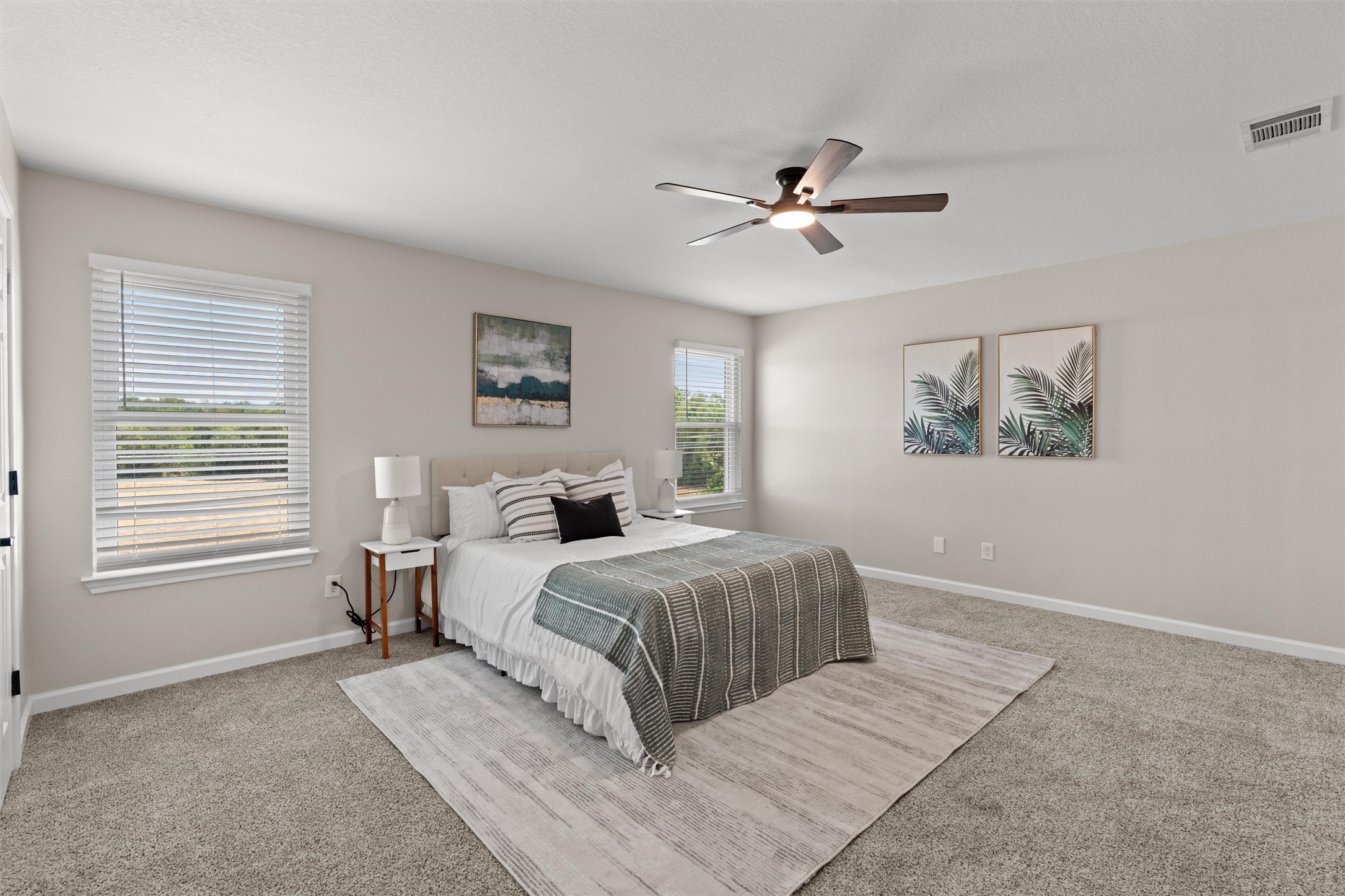 724 Lavaca Loop Elgin, TX 78621 - Photo 14 of 40 Plentiful natural light streams through multiple windows across this comfortable carpeted bedroom.