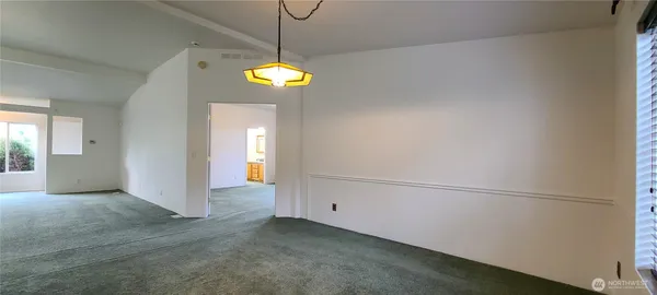 an empty room with windows and ceiling fan