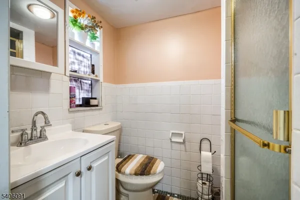 a bathroom with a toilet a sink and mirror