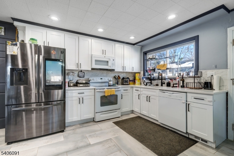 460 Grove Street Rahway, NJ 07065 - Photo 9 of 26 a kitchen with white cabinets stainless steel appliances and window