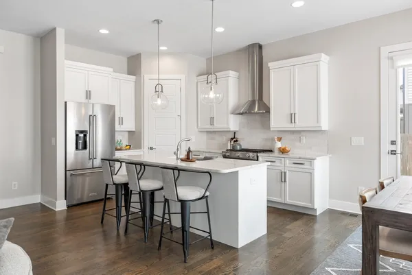 a kitchen with stainless steel appliances granite countertop a table chairs stove a sink and a refrigerator