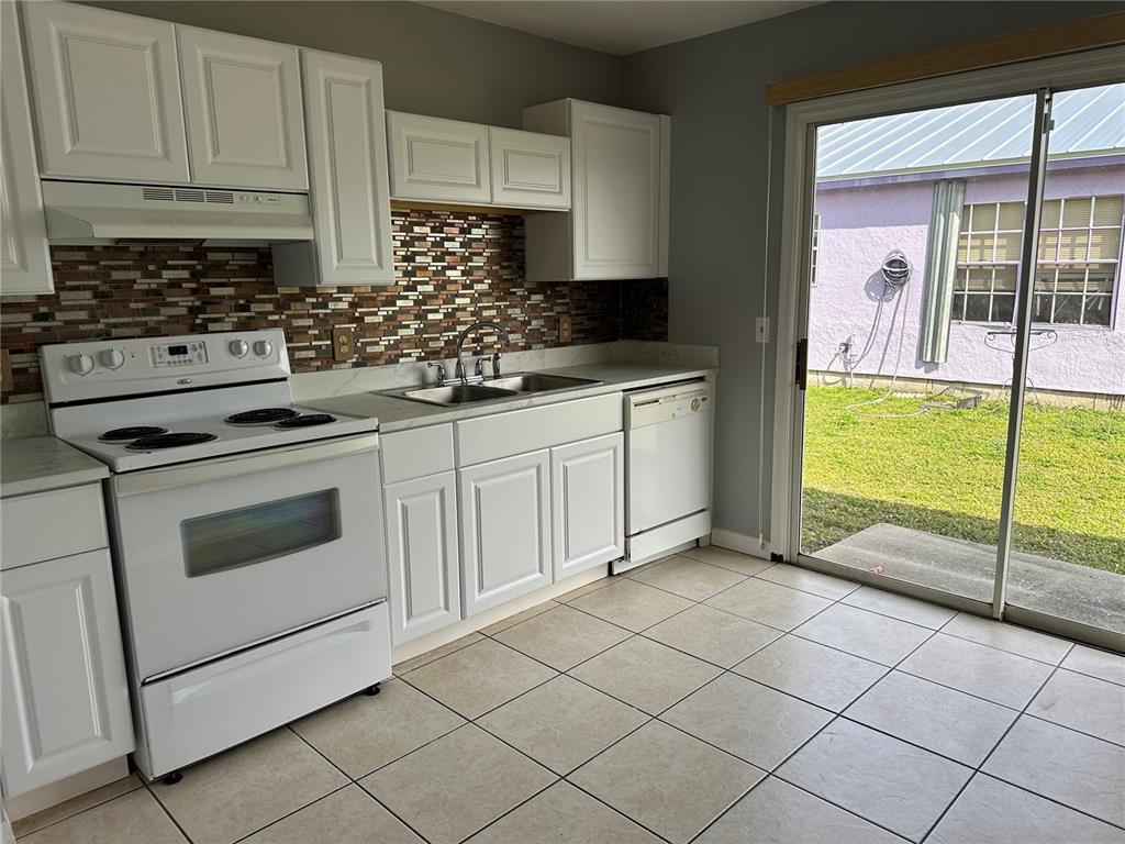 425 Ricold Terrace Port Charlotte, FL 33954 - Photo 3 of 10 a kitchen with granite countertop a stove a sink and a refrigerator