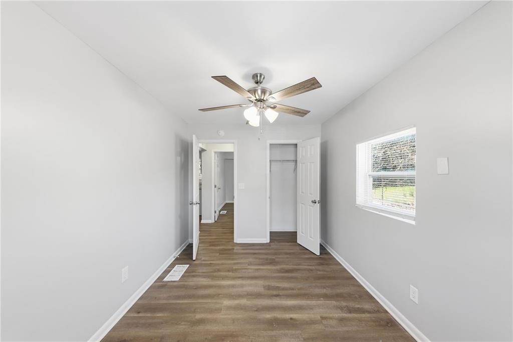 2086 Fairburn Road Southwest Atlanta, GA 30331 - Photo 14 of 28 a view of an empty room with wooden floor and a ceiling fan