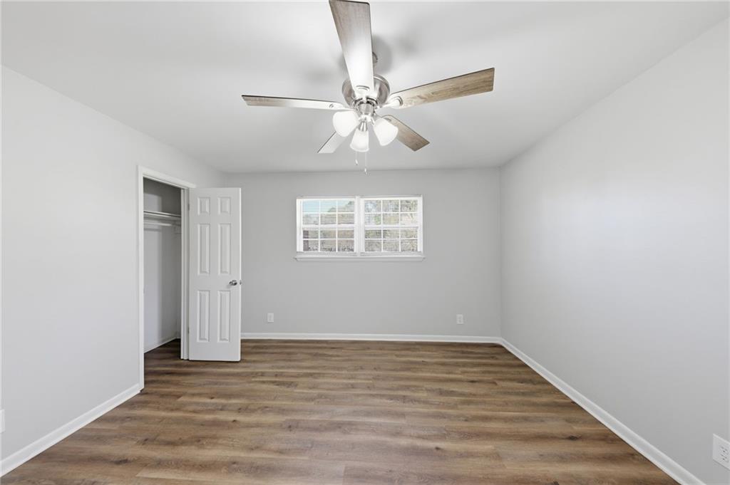 2086 Fairburn Road Southwest Atlanta, GA 30331 - Photo 17 of 28 an empty room with wooden floor chandelier fan and windows