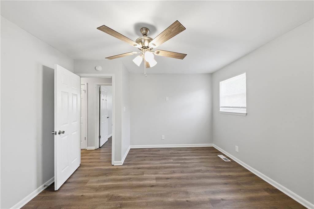 2086 Fairburn Road Southwest Atlanta, GA 30331 - Photo 19 of 28 an empty room with wooden floor fan and windows