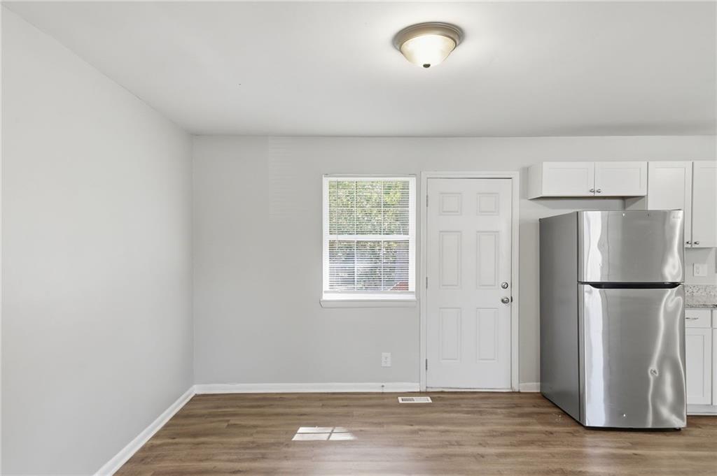 2086 Fairburn Road Southwest Atlanta, GA 30331 - Photo 7 of 28 a view of an empty room with wooden floor and a window
