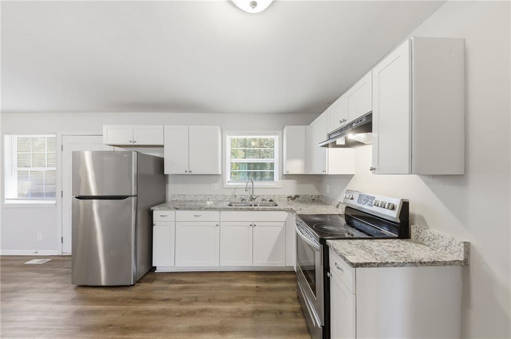 2086 Fairburn Road Southwest Atlanta, GA 30331 - Photo 9 of 28 a kitchen with a sink a refrigerator and white cabinets