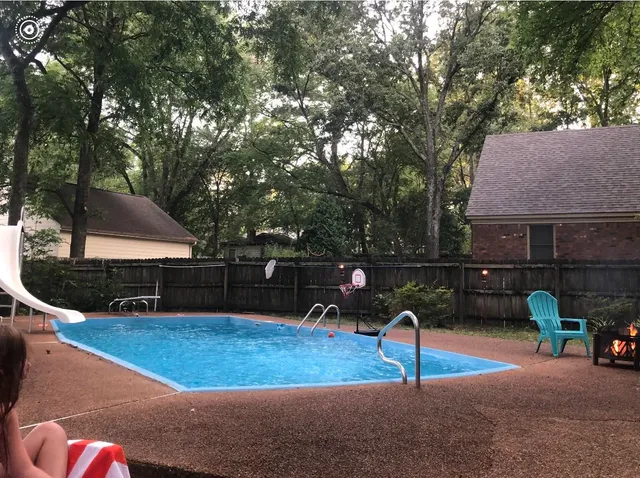 a backyard of a house with table and chairs