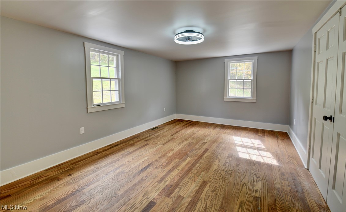 9734 Edwards Ridge Road Southeast Uhrichsville, OH 44683 - Photo 13 of 35 Hardwood floored empty room featuring plenty of natural light