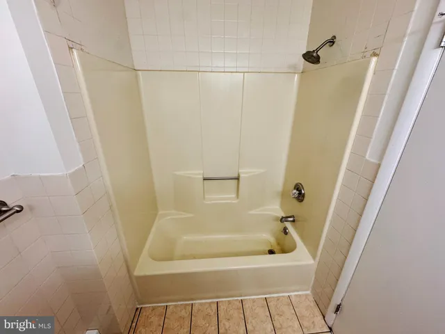a bathroom with a tub a sink and a shower