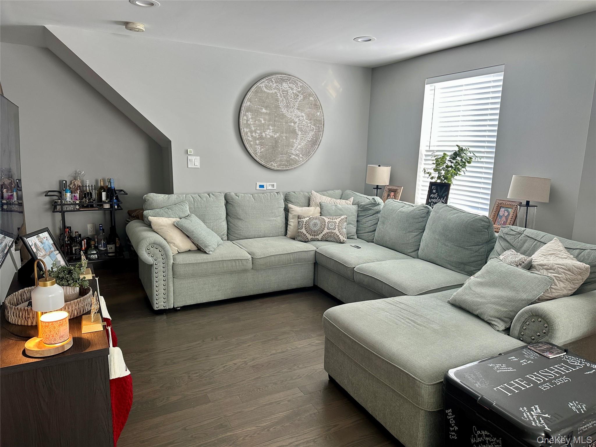 a living room with furniture a clock and a window