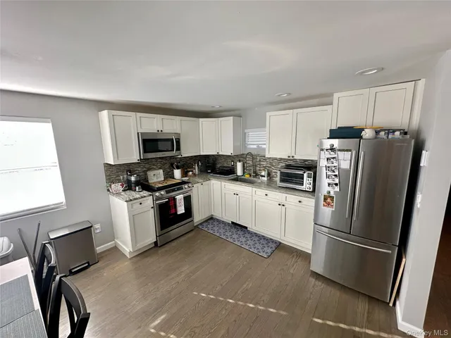 a kitchen with stainless steel appliances a refrigerator sink and microwave