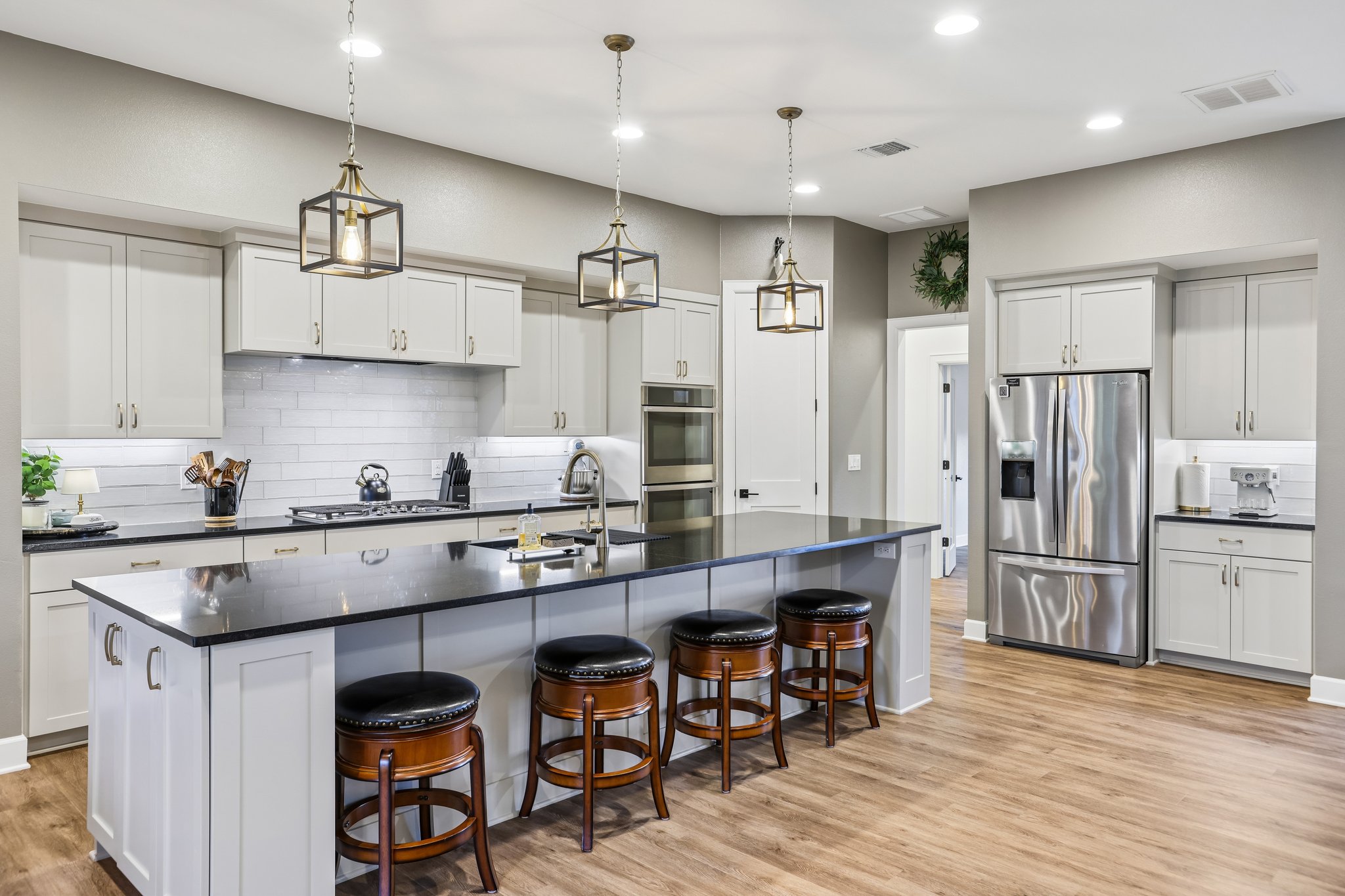 113 Crystal Lane Georgetown, TX 78633 - Photo 2 of 32 A contemporary kitchen showcasing rich dark countertops and gleaming stainless steel appliances.