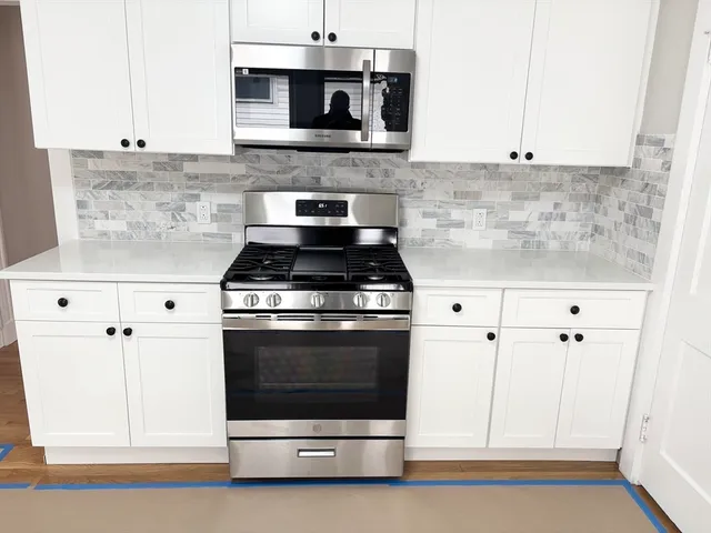 a kitchen with stainless steel appliances white cabinets and a stove