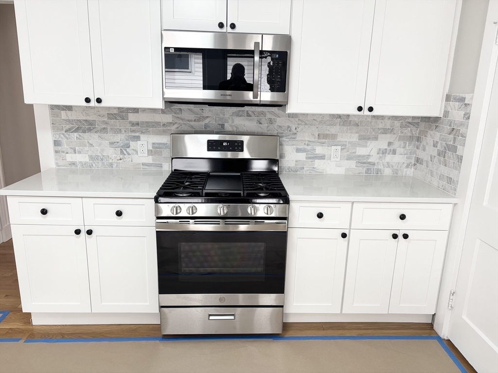 73 Dent Street, Unit 2 Boston, MA 02132 - Photo 11 of 41 a kitchen with stainless steel appliances white cabinets and a stove