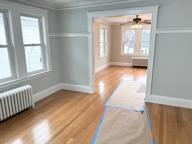 an empty room with wooden floor and windows