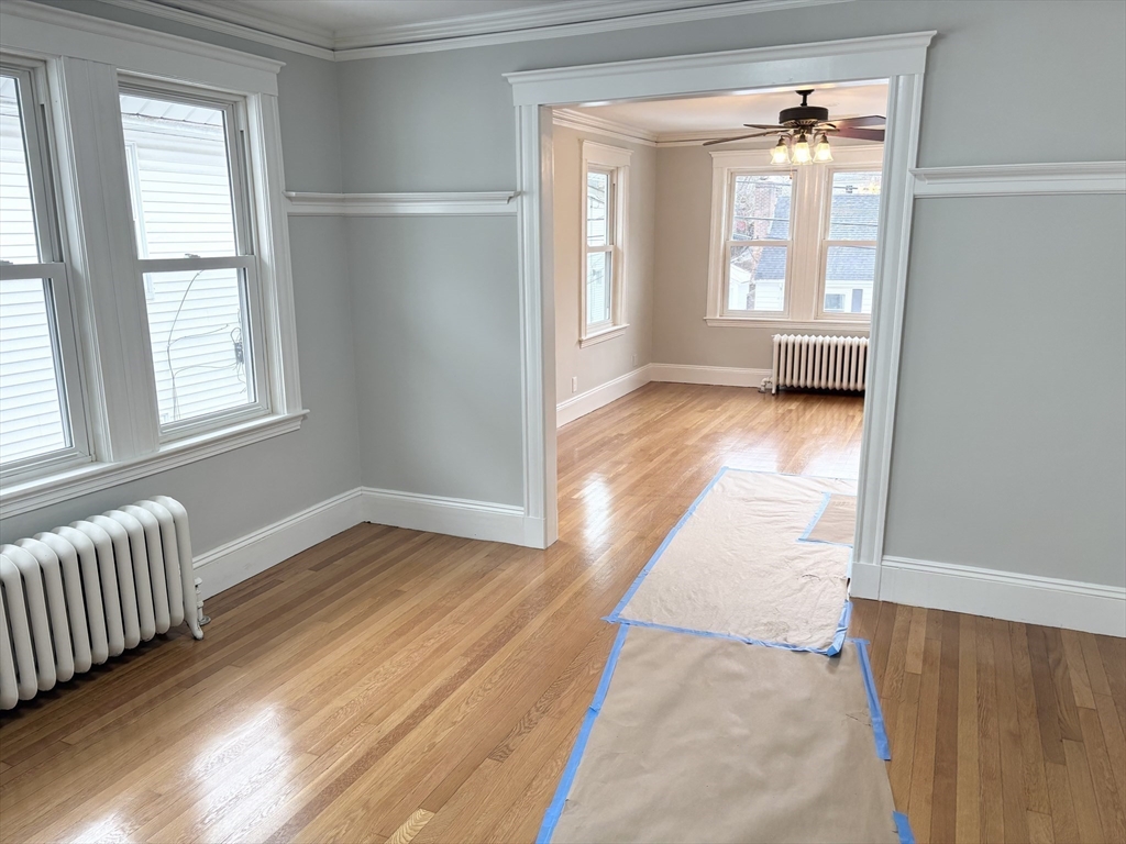73 Dent Street, Unit 2 Boston, MA 02132 - Photo 15 of 41 an empty room with wooden floor and windows