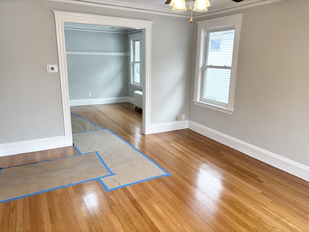 73 Dent Street, Unit 2 Boston, MA 02132 - Photo 16 of 41 an empty room with wooden floor mirror and windows