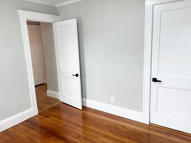 an empty room with wooden floor and entrance