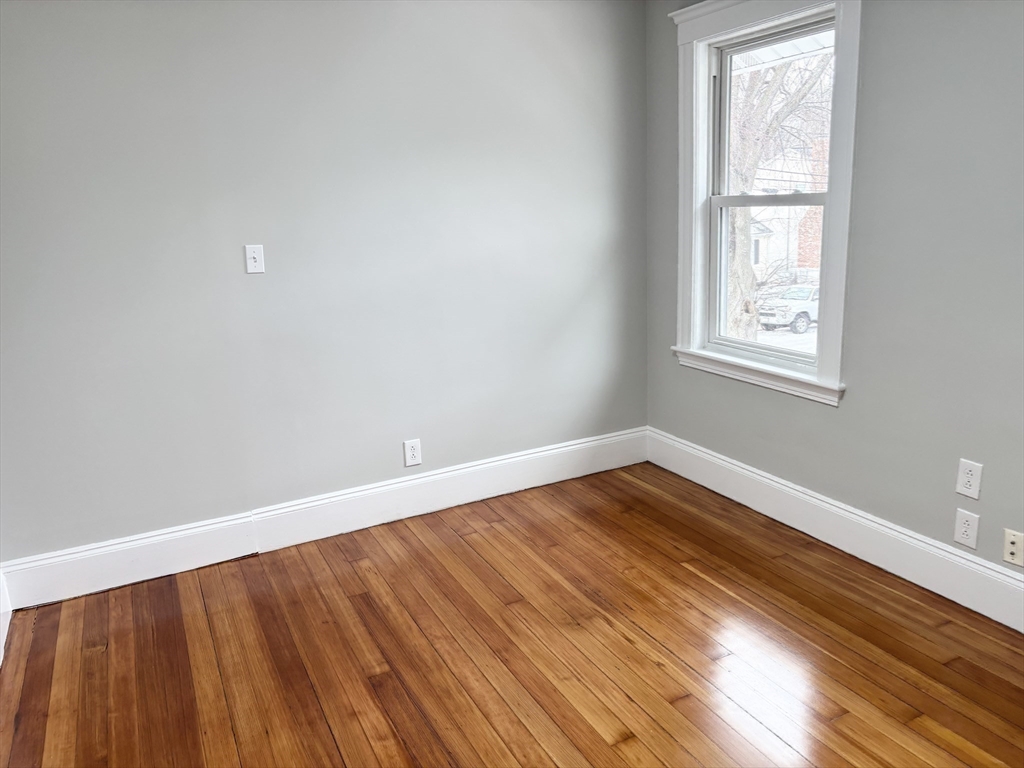 73 Dent Street, Unit 2 Boston, MA 02132 - Photo 30 of 41 a view of an empty room with wooden floor and a window