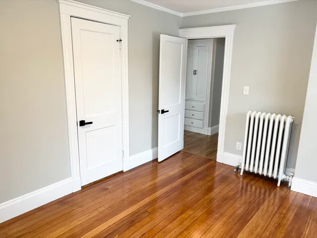an empty room with wooden floor and closet area