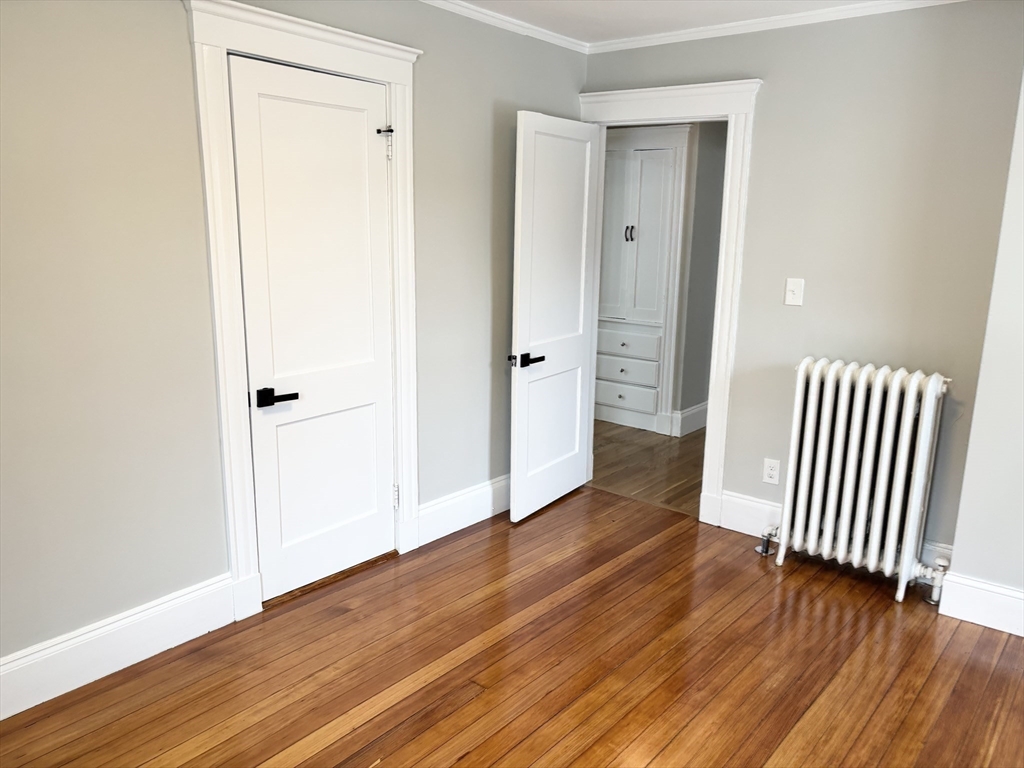 73 Dent Street, Unit 2 Boston, MA 02132 - Photo 32 of 41 an empty room with wooden floor and closet area