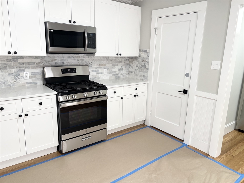 73 Dent Street, Unit 2 Boston, MA 02132 - Photo 9 of 41 a kitchen with stainless steel appliances white cabinets and stove