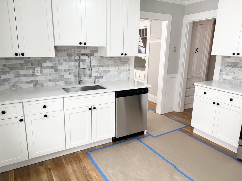 73 Dent Street, Unit 2 Boston, MA 02132 - Photo 10 of 41 a kitchen with granite countertop white cabinets and sink