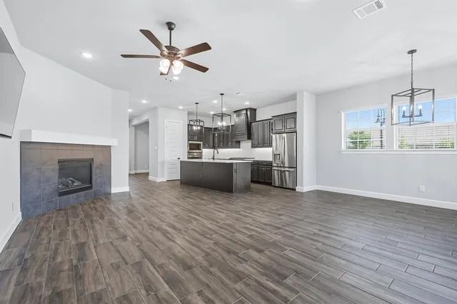 a view of a kitchen with a stove cabinets wooden floor and a ceiling fan