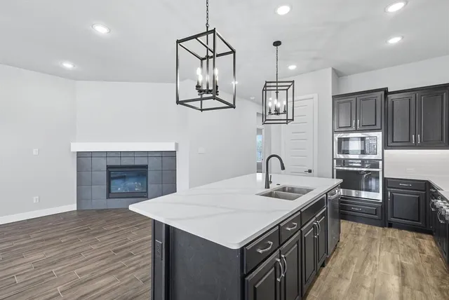 a kitchen with stainless steel appliances granite countertop a kitchen island a stove and a sink